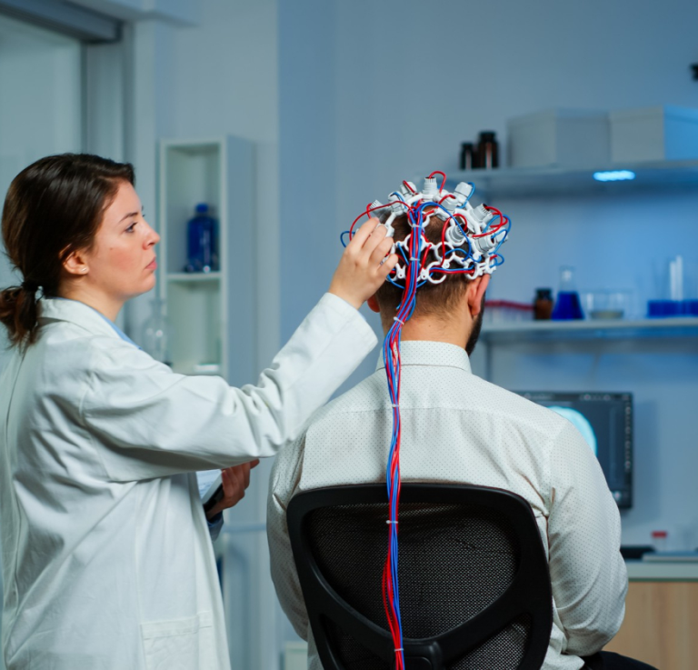 back-view-man-patient-wearing-performant-brainwave-scanning-headset-sitting-neurological-research-laboratory-while-medical-researcher-adjusting-it-examining-nervous-system-typing-tablet_1.png
